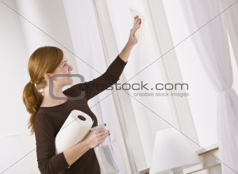 Attractive woman cleaning window