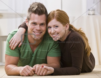 Happy Couple Lying Together On Their Apartment Floor