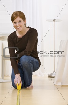 Attractive woman measuring floor