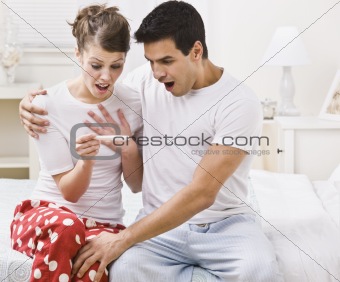 Surprised couple looking at a pregnancy test
