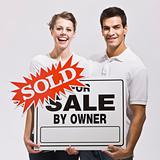 Couple with For Sale by Owner Sign