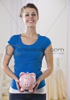 Beautiful woman holding piggy bank.