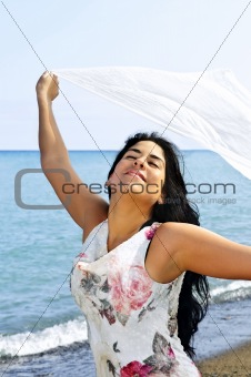 Beautiful young woman at beach with white scarf