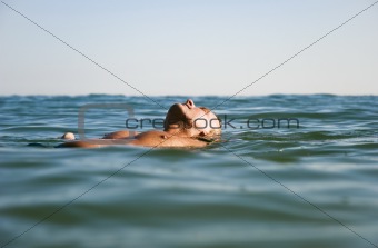 man floating in water.