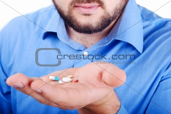 Man's palm with medicine pills on