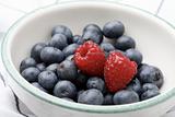 Fresh blueberries and raspberries in a bowl.