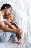 Dad and little girl sleeping on bed