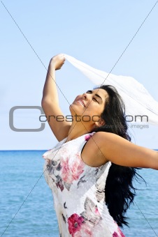 Beautiful young woman at beach with white scarf