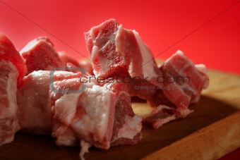 Pig, pork raw meat pieces over red 
