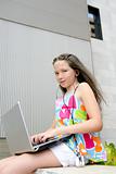 Beautiful brunette teen little girl laptop city