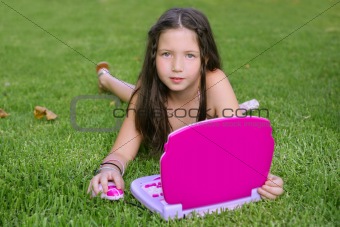 Beautiful little girl playing with pink toy computer 