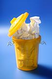 Paper trash in yellow over blue background