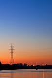 Silhouette of a power transmission line tower support against th