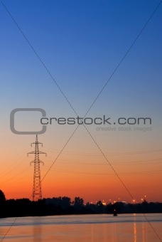 Silhouette of a power transmission line tower support against th