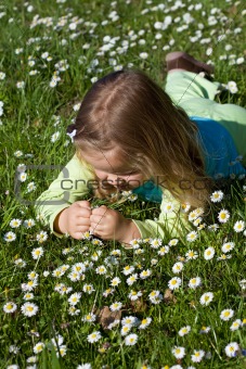Little girl laying among little wildflowers