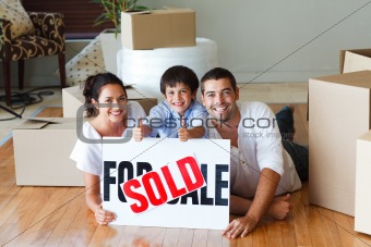 Happy family lying on the floor after buying house