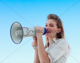 Beautiful businesswoman shouting through megaphone