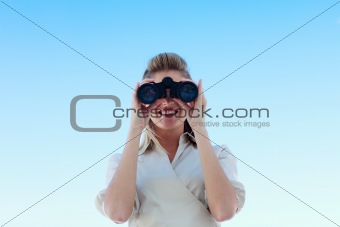 Smiling businesswoman looking through binoculars
