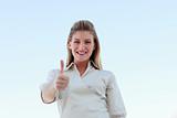 Young businesswoman smiling at the camera with thumbs up