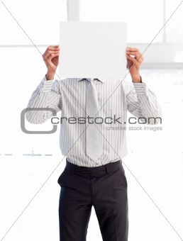 Businessman holding a white card covering his face