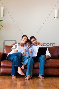 Family using a laptop with thumbs up and copy-space