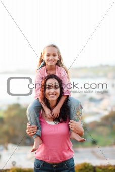 Portrait of a mother giving piggyback ride to child