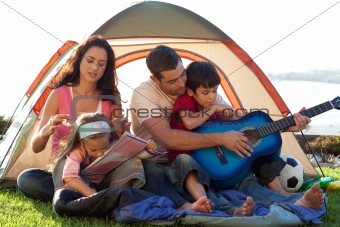 Family camping and playing a guitar