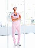 Beautiful nurse standing in front of the camera with folded arms