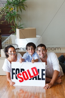 Family on the floor with boxes after buying house