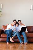 Parents and kid using a laptop with thumbs up and copy-space