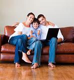 Young family using a labtop on sofa