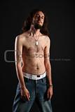 Portrait of rebel with long hair and topless slim body isolated on black background