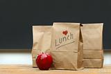 Lunch bags with  apple on school desk