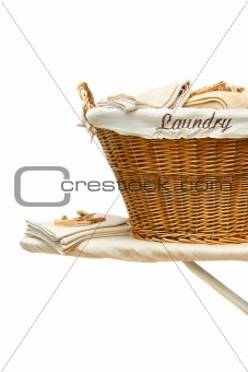 Laundry basket on ironing board against white 