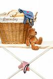 Teddy bear with laundry basket on ironing board 