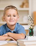 Boy Sitting in Front of Soccer Trophy