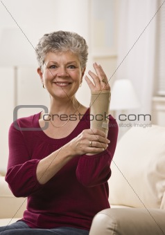 Woman Putting Brace on Hand