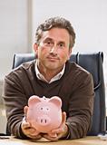 Man Holding Piggy Bank