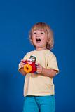 studio shot of a cheerful boy with a colorful plastic camera