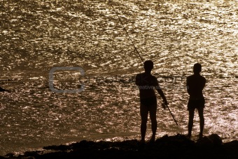 two friends fishing in black silhouette