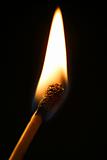One match in flame over black background