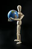 Wooden little mannequin holding the world map
