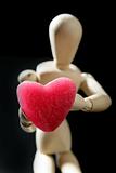 Wooden mannequin holding a red jelly  heart shape