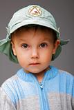 Closeup portrait of a little boy in a cap, serious attentive loo