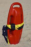 Red plastic buoyancy aid in the sand