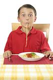 Child sucking long pasta through lips