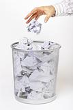 Hand throwing rubbish in waste paper basket
