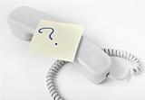 Telephone handset with a question mark post it note