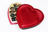 Heart shaped box of candy with lid partially on