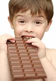 The boy bites a chocolate tile
